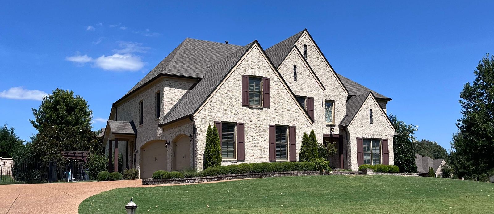 New architectural shingle roof on a two-story stone home in Collierville TN
